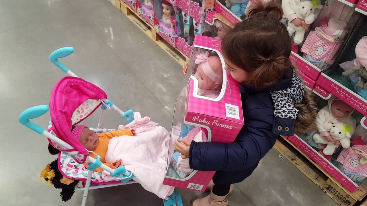 дівчинка вибирає коляску для ляльки в магазині